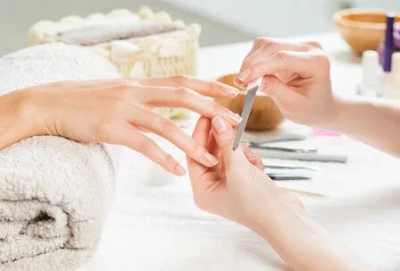 Manicure at GRANDSPA, GRAND HOTEL Zell am See A manicure is being performed on a hand on a bright treatment table.
